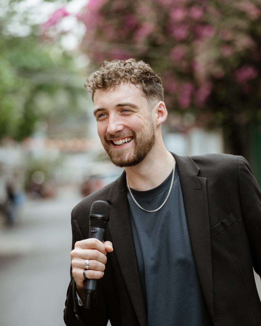 Chris Cashen smiling, holding a microphone