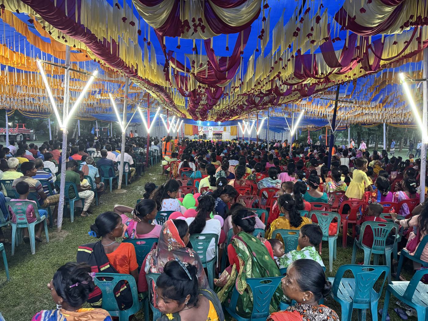 A packed crusade tent at dusk in Bangladesh