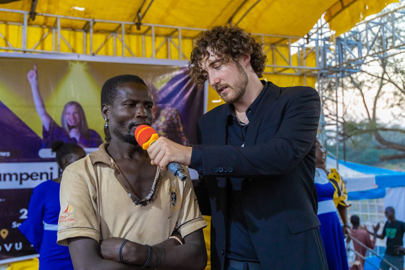 Chris on stage with a man sharing his testimony at the crusade in Kakuma, Kenya