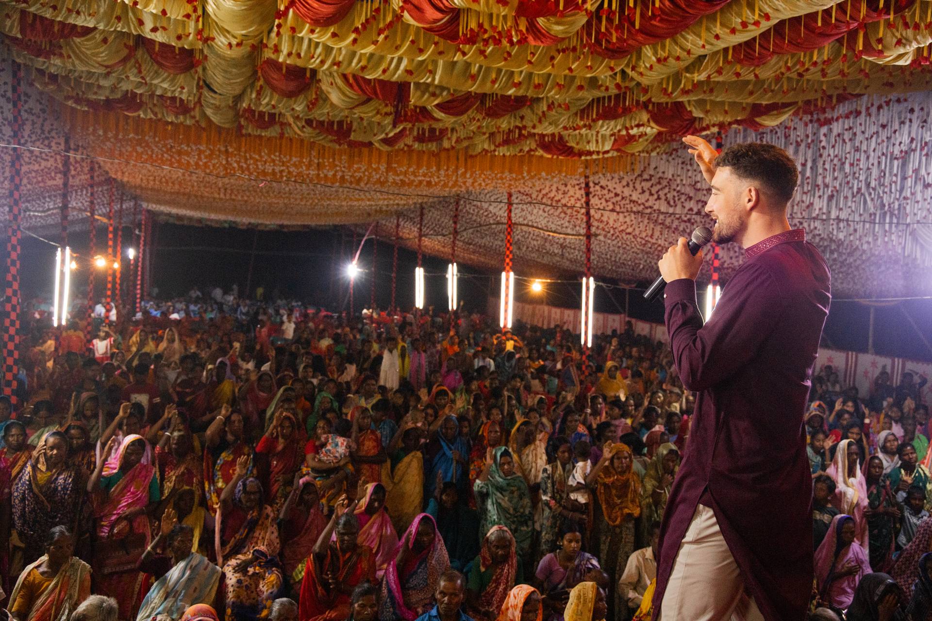 Chris preaching to a packed crusade crowd at night in Bangladesh