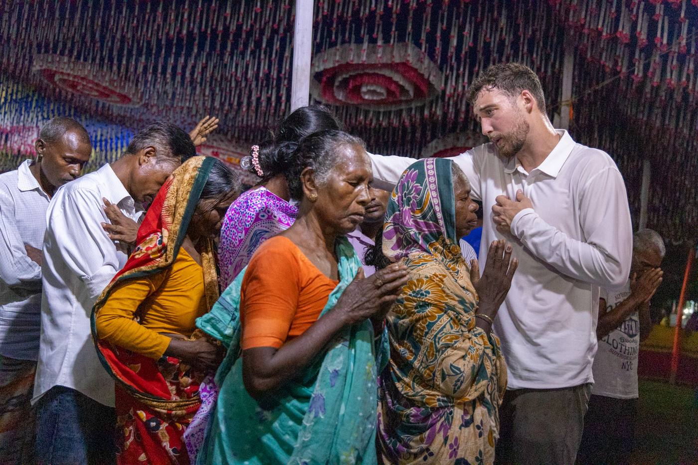 Chris praying with women at a crusade in Bangladesh